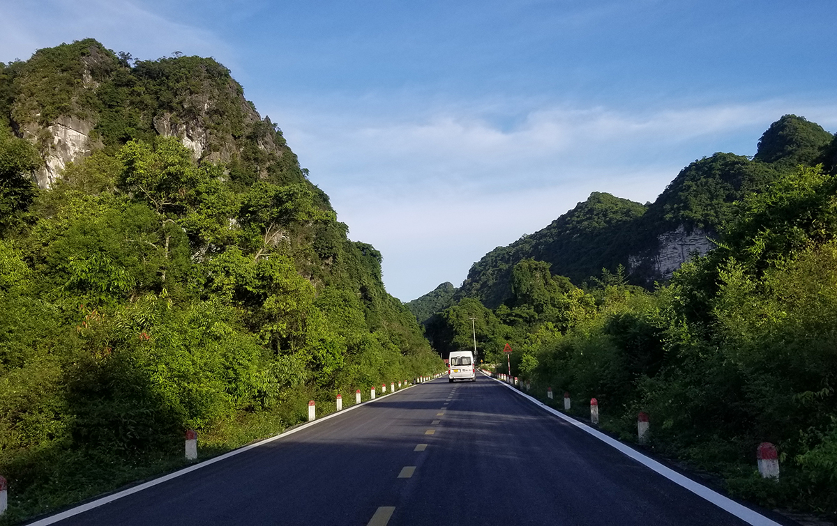Hun hút hai bên đường là rừng cây nhiệt đới và dãy núi đá vôi trùng điệp