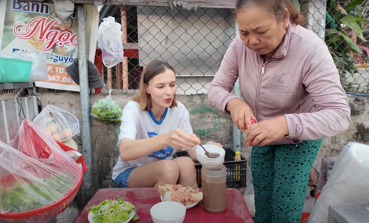 Nữ du khách Belarus lần đầu ăn bánh xèo với mắm nêm.
