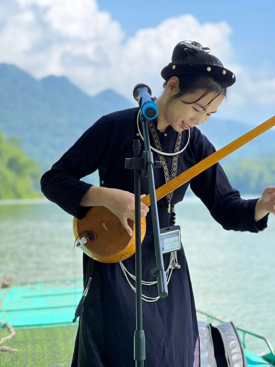 Hướng dẫn viên người địa phương hát then và chơi đàn tính khi dẫn tour cho khách trên hồ Ba Bể.