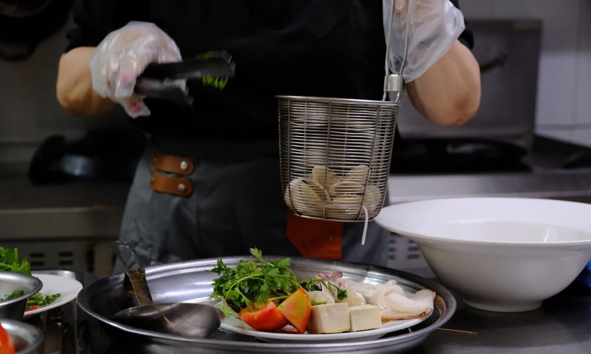 Tôm hùm gần chín, đầu bếp sẽ trụng nghêu và mực vào nước dùng khoảng năm phút.