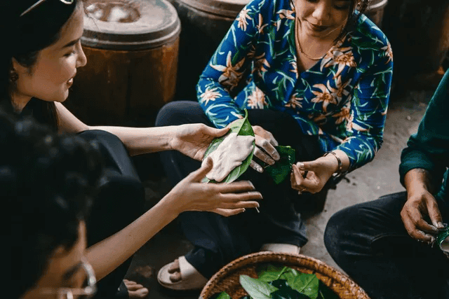 Người đẹp đang trải nghiệm làm bánh lá mít cùng người dân ở khu Cồn Sơn